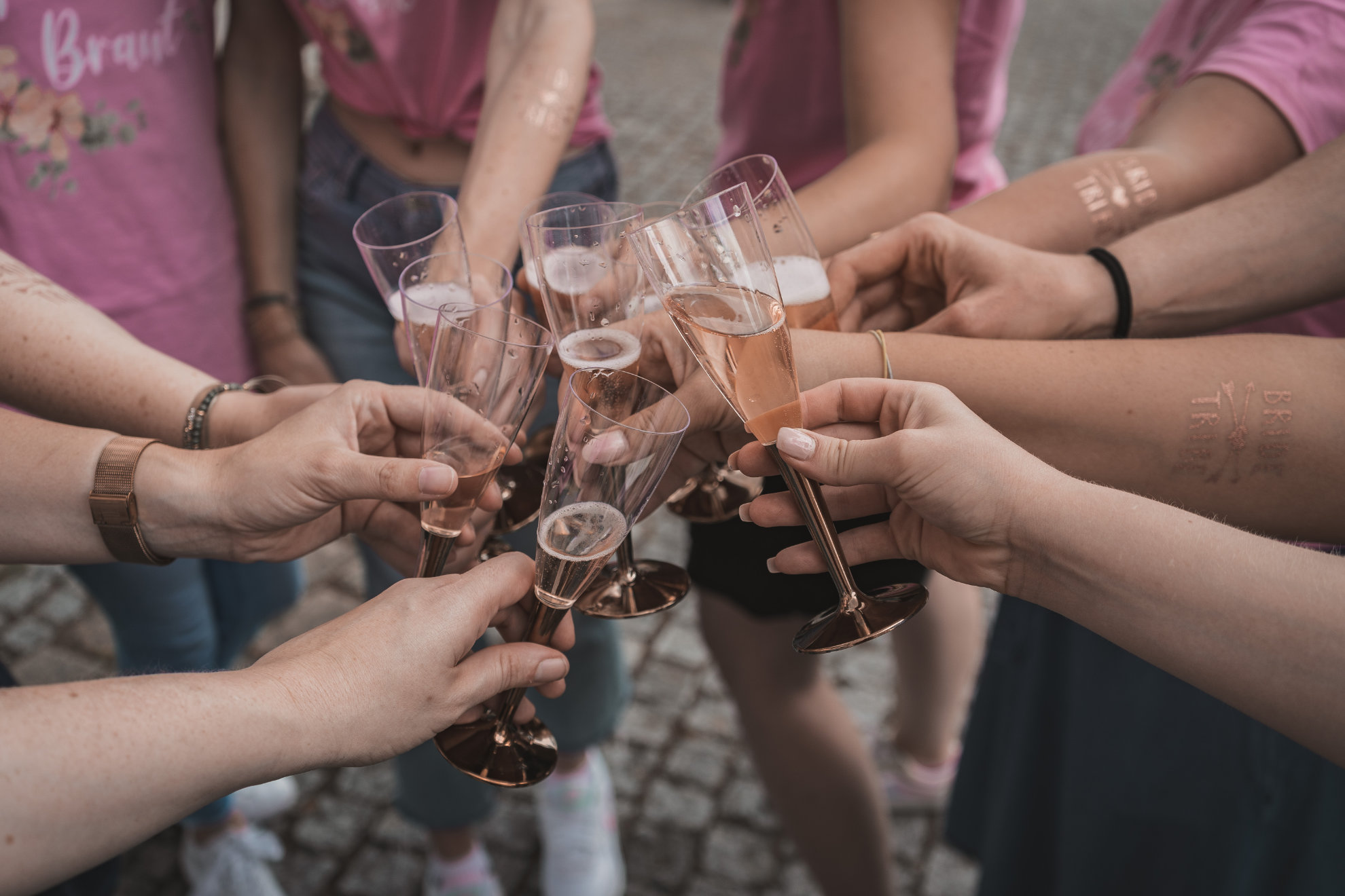 Sekt wird in Kupferbecher gegossen, die Gruppe hält sie zusammen hoch
