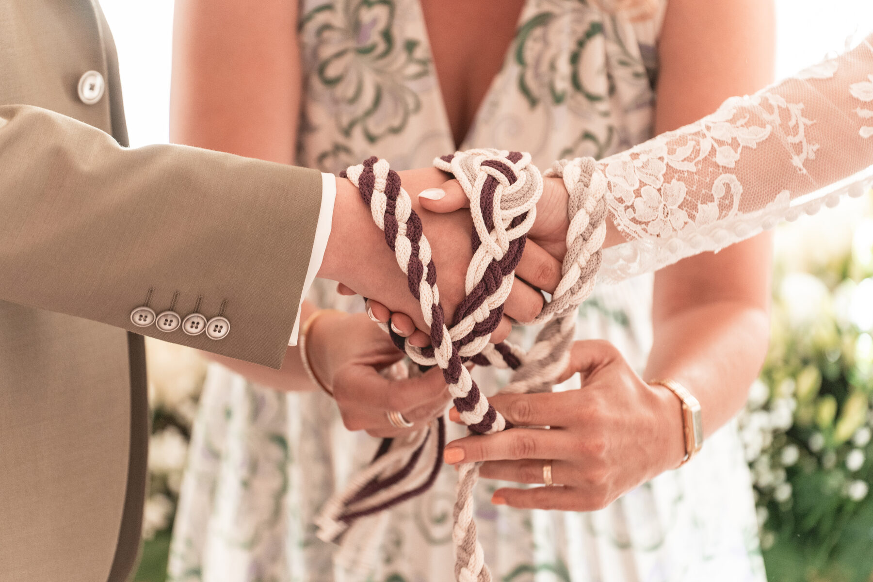 Detailaufnahme der zusammengebundenen Hände des Brautpaars beim Handfasting
