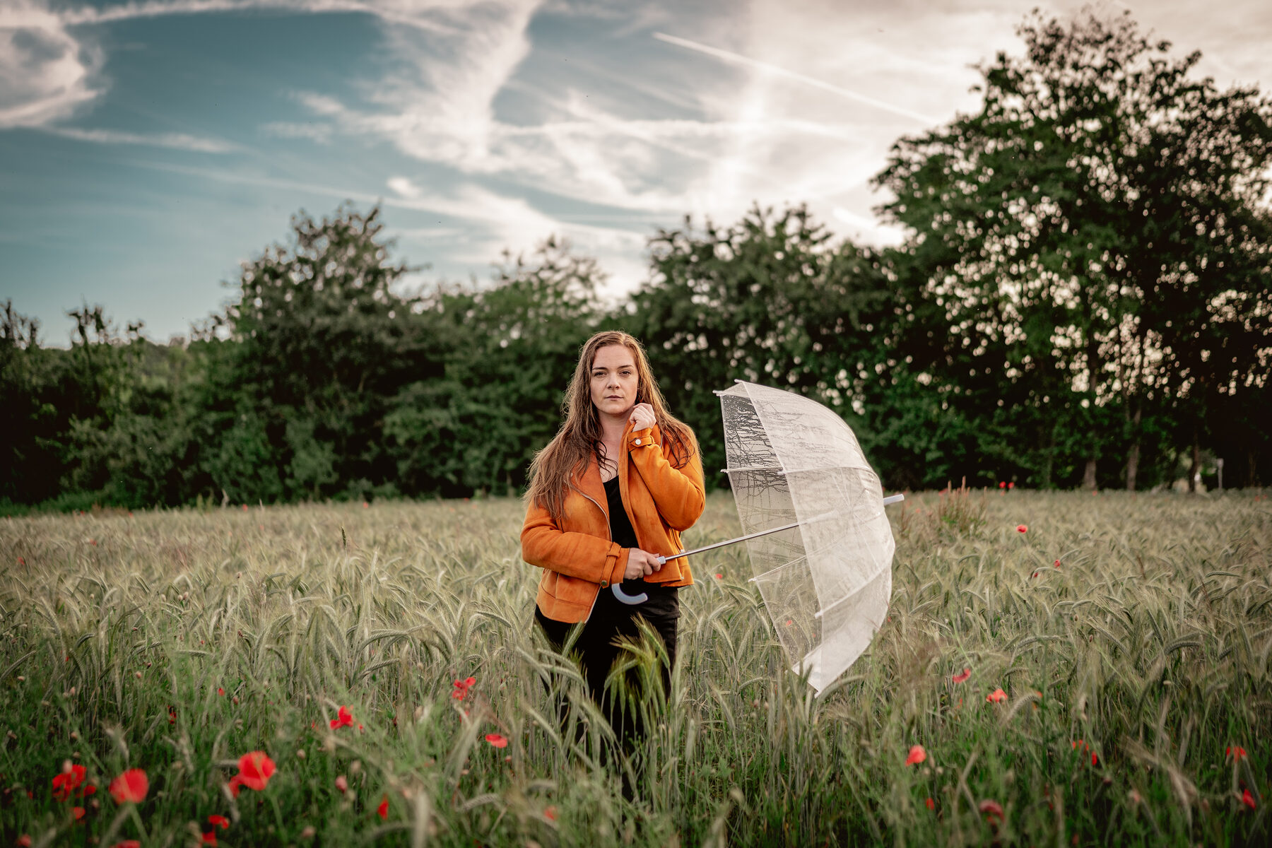 Frau mit weißem Schirm in einem Feld mit Mohnblumen